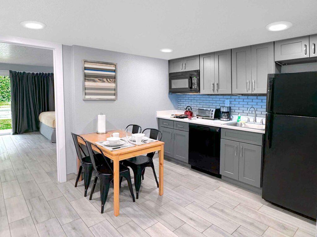Cozinha de uma suíte reformada do Celebration Suites, com cooktop, geladeira grande e armários