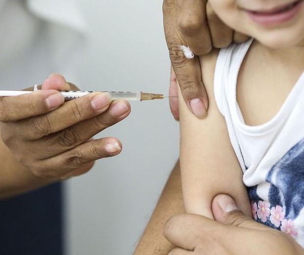 crianca sendo vacinada