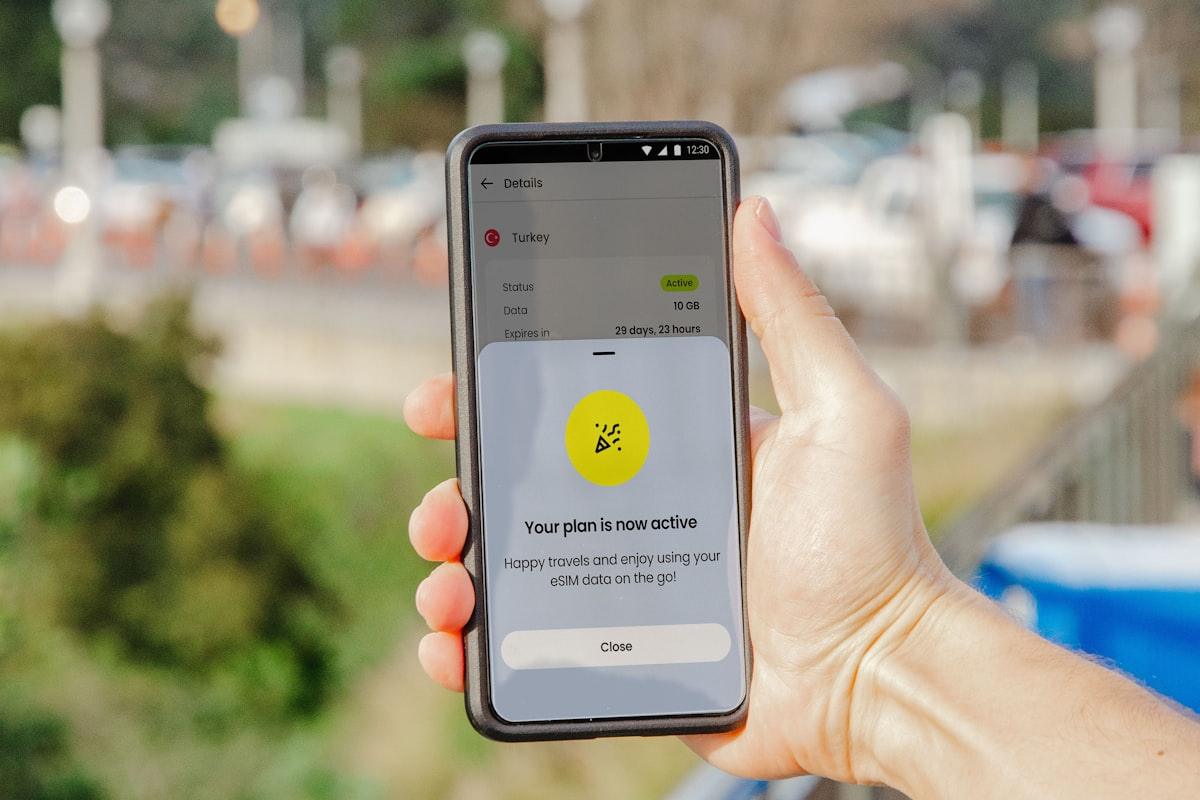 Pessoa segurando celular nas mãos para ativar o eSIM