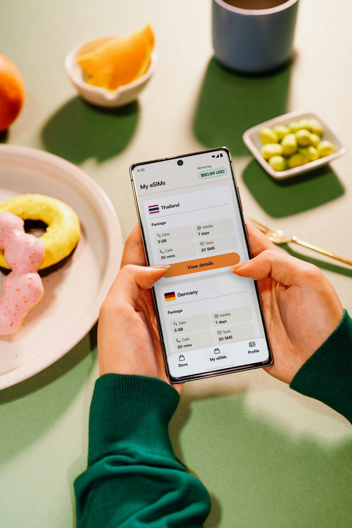 Pessoa segurando smartphone com aplicativo de viagem aberto