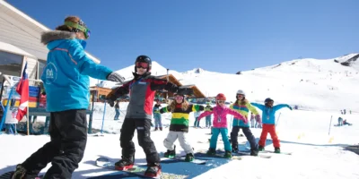 Alunos iniciantes durante aula de esqui em área plana no Valle Nevado