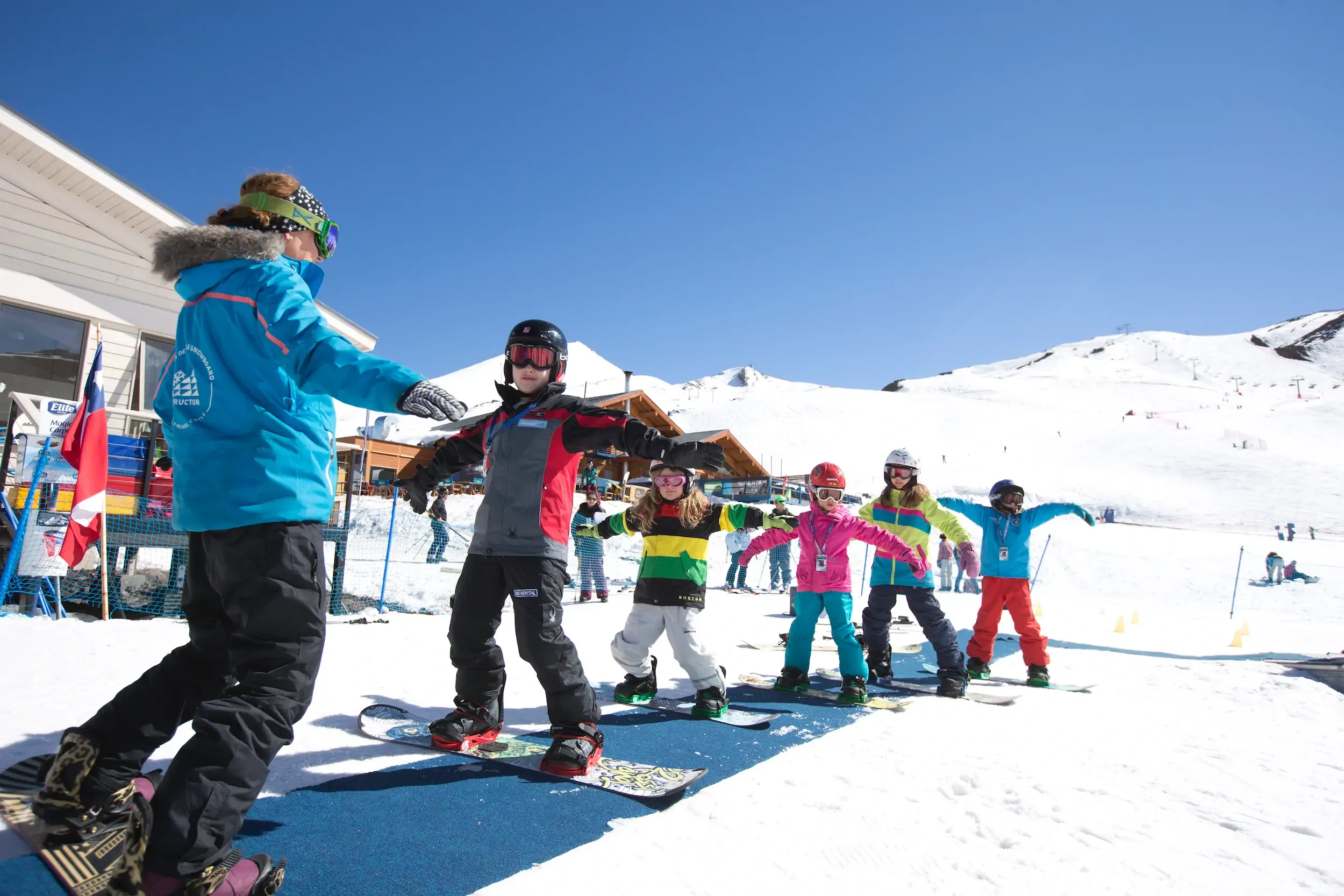 Alunos iniciantes durante aula de esqui em área plana no Valle Nevado