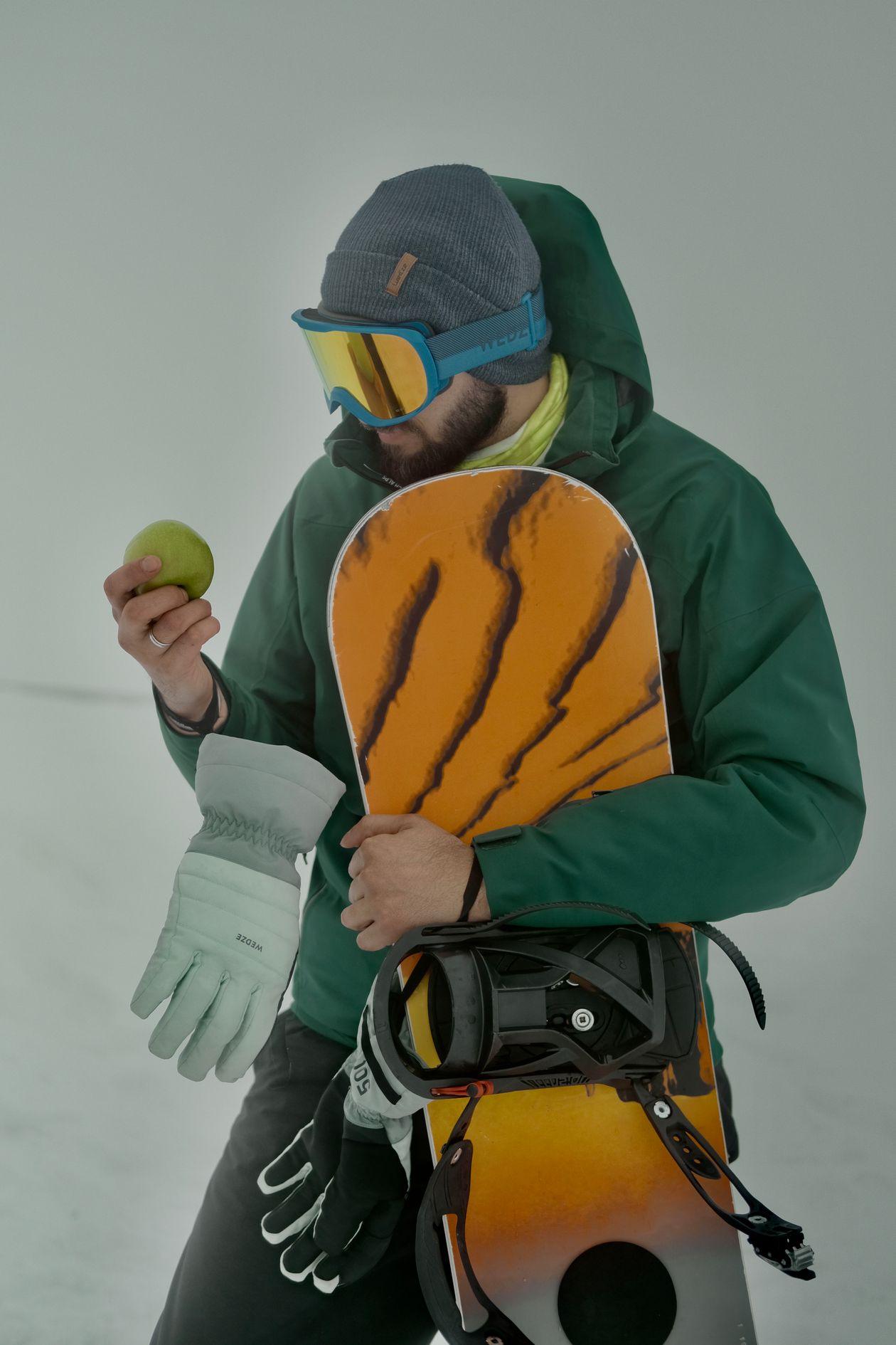 Praticante de snowboard usando óculos de neve (goggles) e luvas