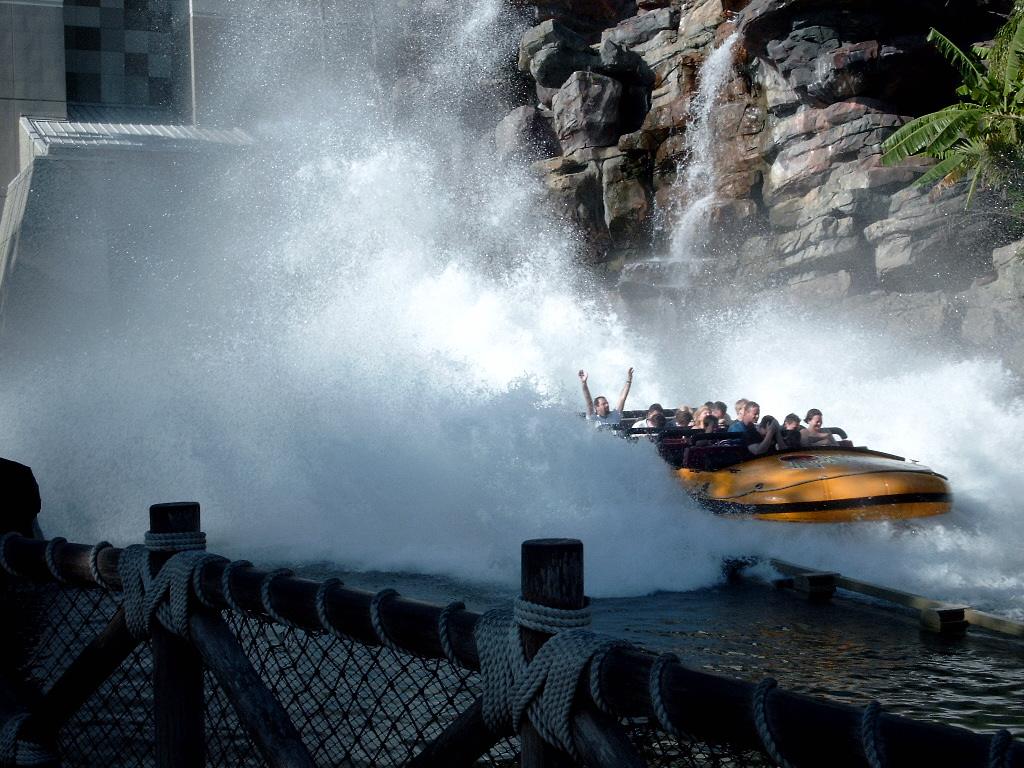 Barco do Jurassic Park River Adventure descendo a queda final e espirrando água, no Islands of Adventure, em Orlando
